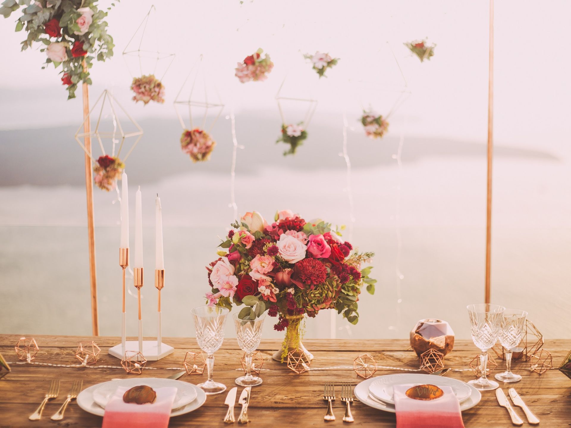 A wedding centerpiece with red and pink flowers.