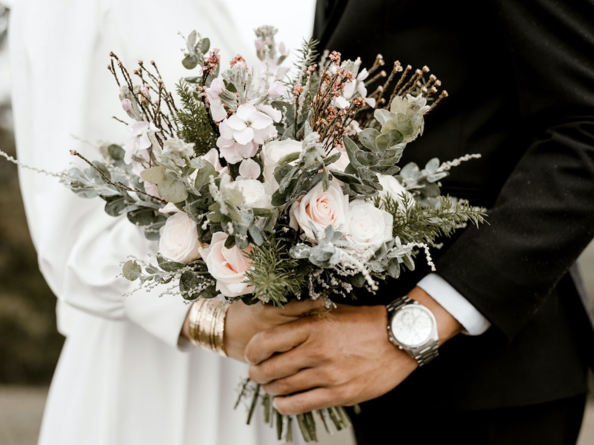 A bride holding a pink and sage green bouquet with text over the photo that says fall wedding color ideas.