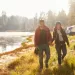 A couple walking near a lake.