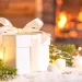 A white gift box sitting next to a lit fireplace.