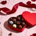 A table with red roses and chocolate truffles.