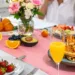 A group of girls around a table packed with brunch items.