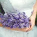 A bride holding a lavender wedding bouquet.
