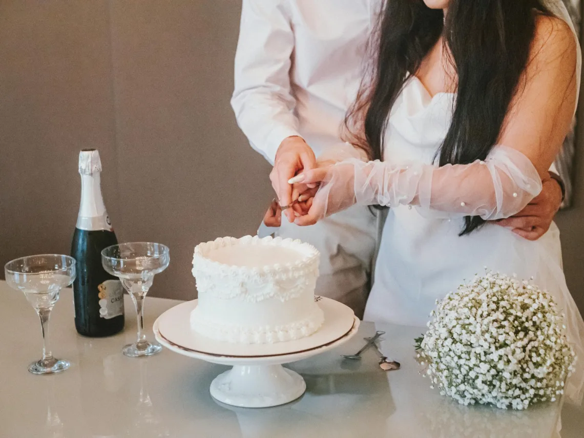 A bride and groom cutting a wedding cake.