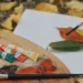 Canvas and paints sitting on top of a pile of leaves.