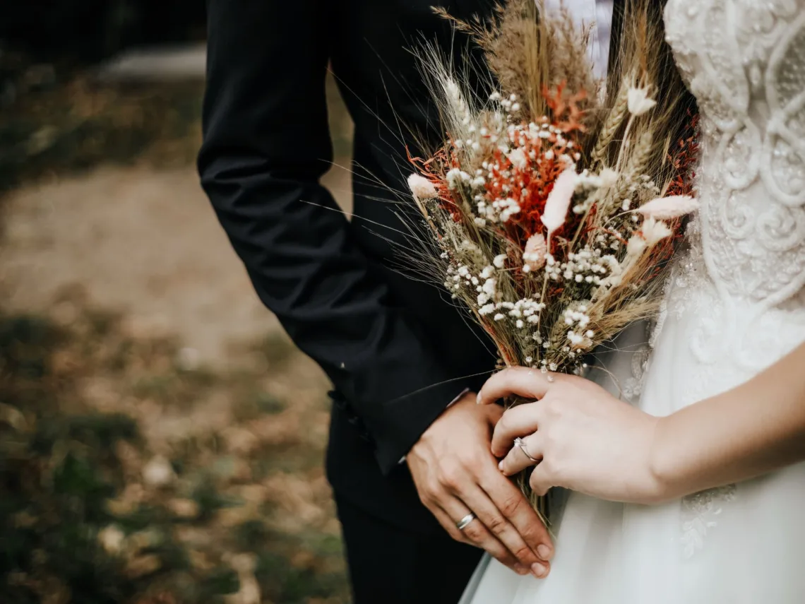 A bride holding a rustic fall wedding bouquet.