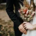 A bride holding a rustic fall wedding bouquet.