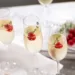 A glass of champagne with fresh raspberries in them.