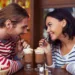 A couple sharing a chocolate milkshake.
