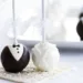 A table with white and black cake pops.