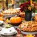 A fall wedding table with pumpkins and a variety of pies.